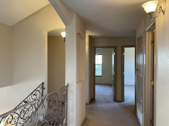 hallway with carpet flooring and arched walkways