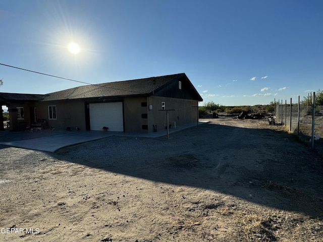 121 Compa Dr, Tornillo, TX 79853 - view of property exterior featuring an attached garage, fence, driveway, and stucco siding