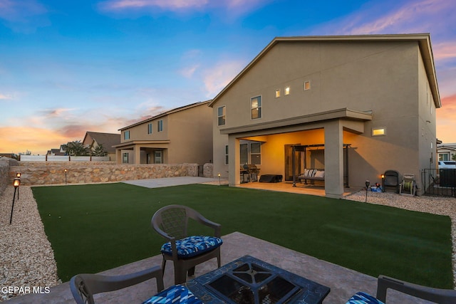 14717 Tierra Escape Ave, El Paso, TX 79938 - back of house at dusk with a patio area, stucco siding, and an outdoor fire pit