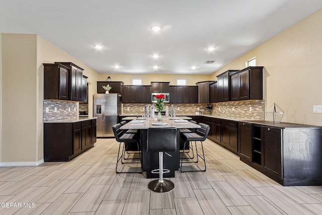 14717 Tierra Escape Ave, El Paso, TX 79938 - kitchen featuring appliances with stainless steel finishes, wood finish floors, a kitchen breakfast bar, dark brown cabinets, and recessed lighting