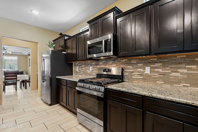 14717 Tierra Escape Ave, El Paso, TX 79938 - kitchen featuring stainless steel appliances, decorative backsplash, light stone counters, dark brown cabinetry, and light wood-style flooring