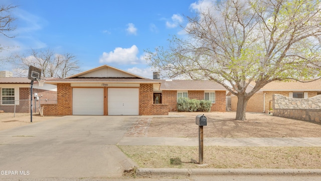 ranch-style home with a garage, fence, driveway, and brick siding
