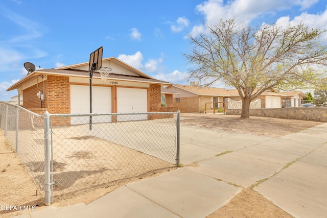 exterior space with an attached garage, fence, and brick siding