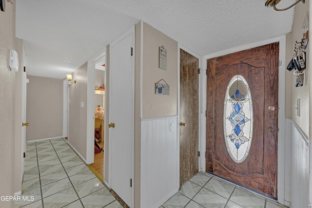 entrance foyer featuring a wainscoted wall and a textured ceiling