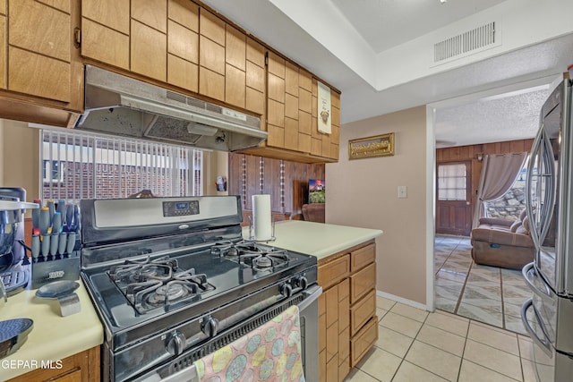 kitchen featuring a textured ceiling, visible vents, under cabinet range hood, light countertops, and stainless steel appliances