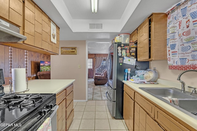kitchen with visible vents, black range with gas cooktop, light tile patterned floors, a sink, and light countertops