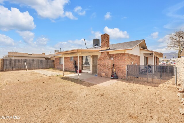 back of house featuring a patio area, a fenced backyard, central AC unit, and brick siding