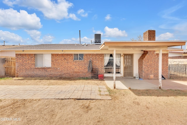 back of house with central air condition unit, a patio, fence, and brick siding