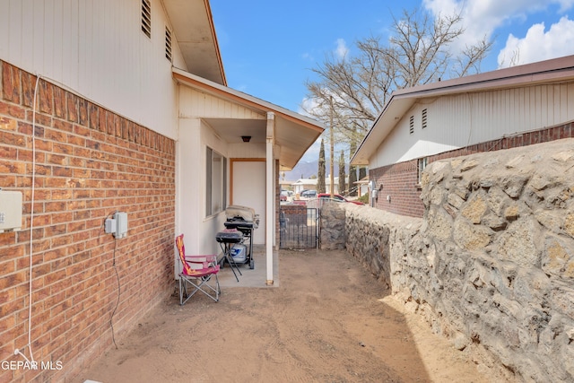 view of patio with grilling area and a gate