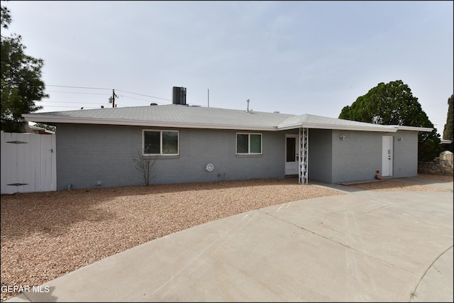 view of front of home with brick siding, fence, and a patio area