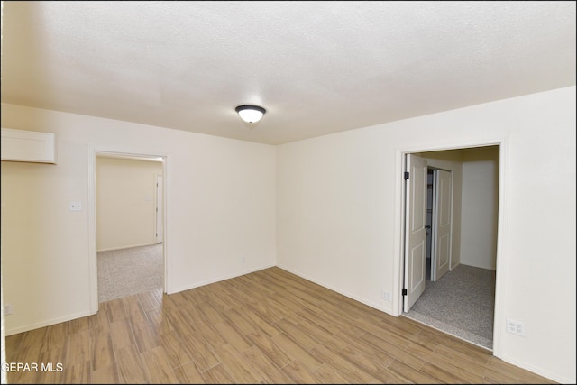 spare room featuring a textured ceiling and light wood-style flooring