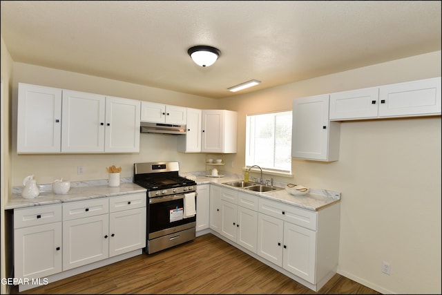 kitchen featuring white cabinetry, a sink, under cabinet range hood, and gas stove