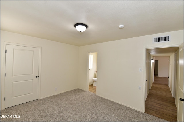 carpeted empty room with baseboards and visible vents