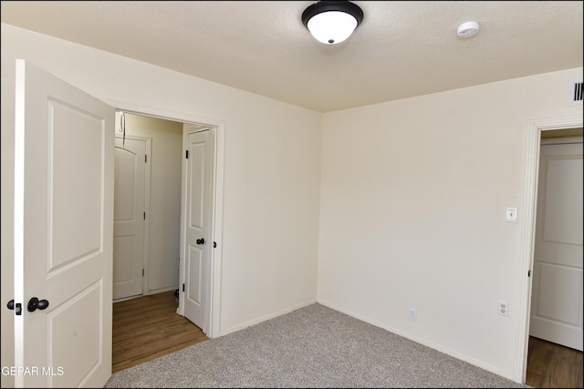 empty room featuring carpet, baseboards, and visible vents