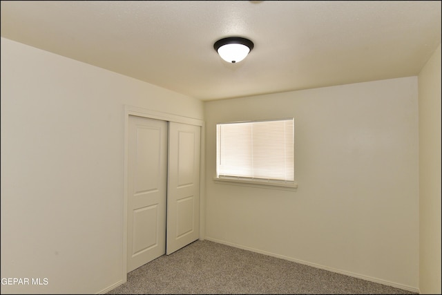 carpeted empty room featuring baseboards