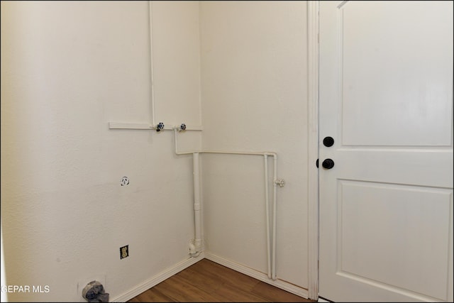 laundry area with baseboards, wood finished floors, and laundry area