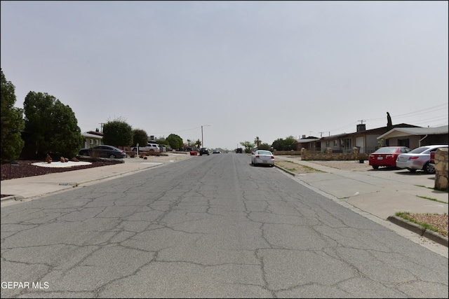 view of road featuring curbs, street lights, and sidewalks