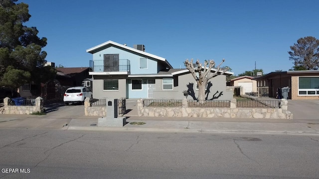 3316 Slocum St, El Paso, TX 79936 - view of front facade with a balcony, a fenced front yard, concrete driveway, and stucco siding