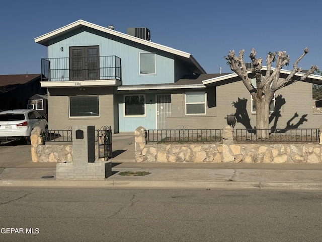 3316 Slocum St, El Paso, TX 79936 - view of front of home with central AC, a balcony, brick siding, and a fenced front yard