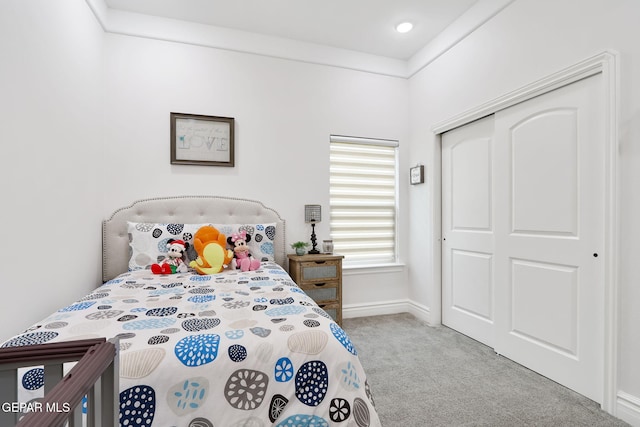 carpeted bedroom featuring a closet and baseboards