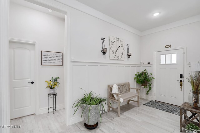 entryway featuring light wood-style flooring and a decorative wall