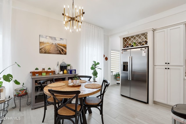 dining area with a chandelier and light wood finished floors