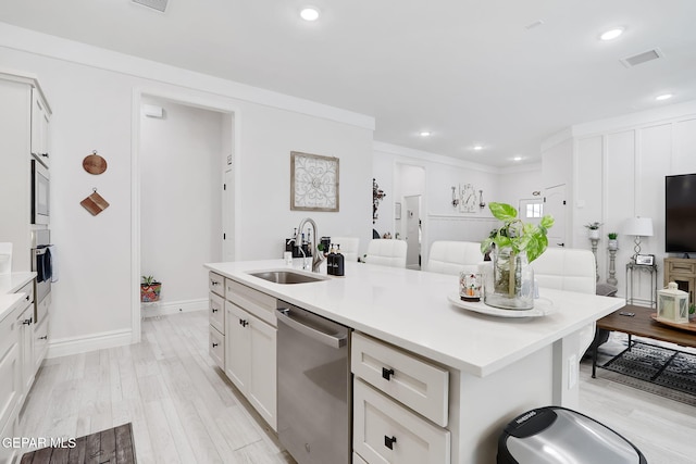 kitchen with light wood-style floors, white cabinetry, appliances with stainless steel finishes, a kitchen island with sink, and a sink