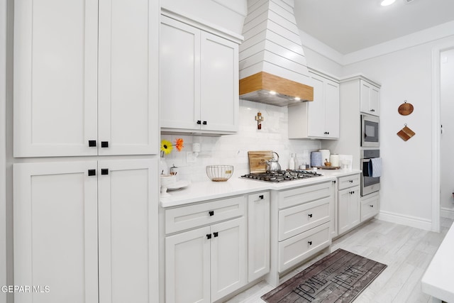 kitchen featuring appliances with stainless steel finishes, decorative backsplash, light countertops, and white cabinetry