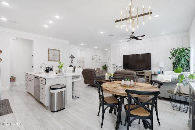 dining space featuring ornamental molding, light wood-type flooring, recessed lighting, and ceiling fan with notable chandelier