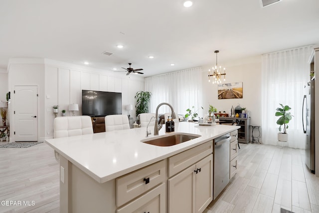 kitchen with an island with sink, light countertops, a sink, stainless steel appliances, and open floor plan