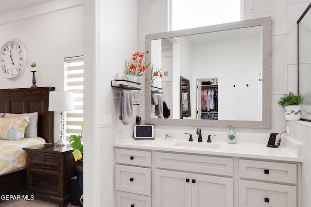 bathroom featuring a walk in closet and vanity