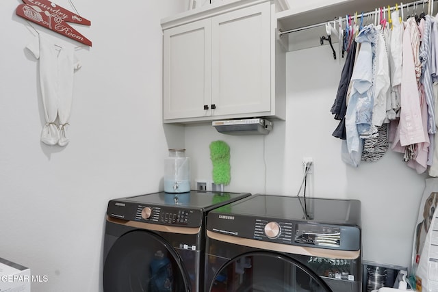 washroom with washing machine and dryer and cabinet space