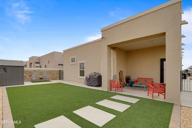 back of house with stucco siding, an outdoor structure, a patio area, a storage shed, and fence