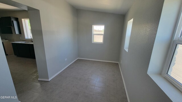 231 Francis St, El Paso, TX 79905 - spare room with baseboards, a sink, a wealth of natural light, and tile patterned flooring