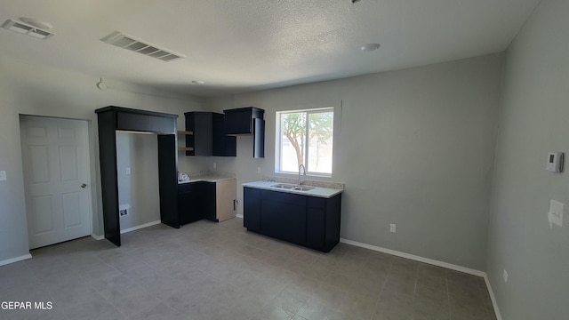 231 Francis St, El Paso, TX 79905 - kitchen with visible vents, a sink, baseboards, and light countertops
