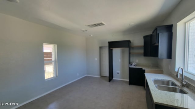 231 Francis St, El Paso, TX 79905 - kitchen with visible vents, light stone countertops, baseboards, light floors, and a sink