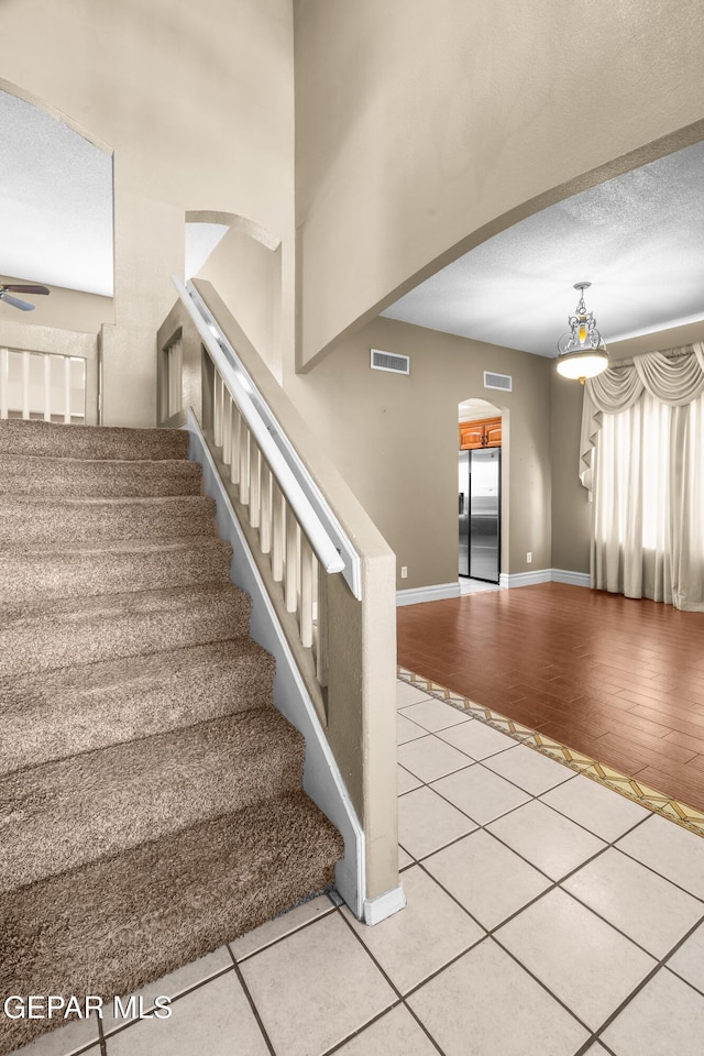 2987 Tierra Limon Dr, El Paso, TX 79938 - stairway featuring arched walkways, tile patterned flooring, baseboards, and ceiling fan