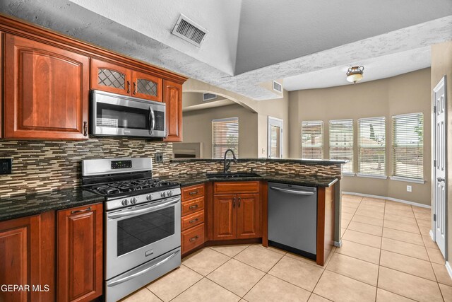 2987 Tierra Limon Dr, El Paso, TX 79938 - kitchen featuring appliances with stainless steel finishes, a sink, backsplash, a peninsula, and light tile patterned flooring