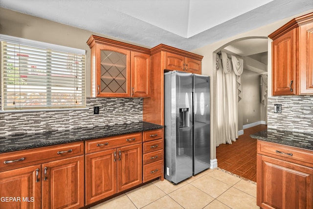 2987 Tierra Limon Dr, El Paso, TX 79938 - kitchen with stainless steel fridge, arched walkways, decorative backsplash, light tile patterned flooring, and baseboards