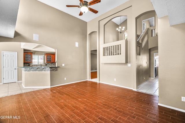 2987 Tierra Limon Dr, El Paso, TX 79938 - unfurnished living room with ceiling fan, a towering ceiling, baseboards, and wood finished floors