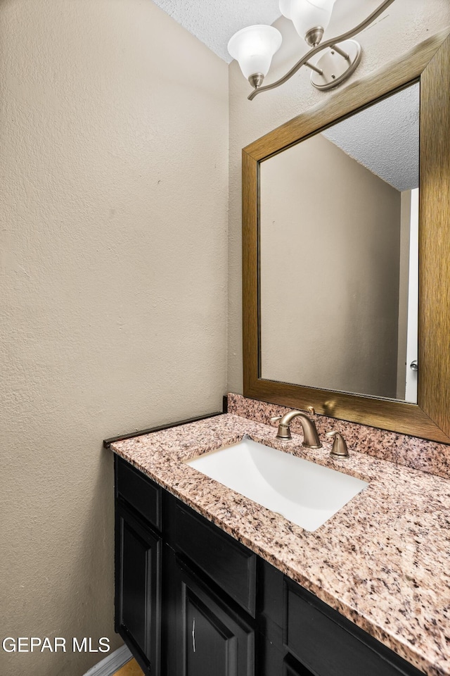 2987 Tierra Limon Dr, El Paso, TX 79938 - bathroom with a textured ceiling, a chandelier, a textured wall, and vanity