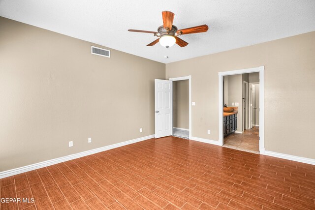 2987 Tierra Limon Dr, El Paso, TX 79938 - unfurnished bedroom with baseboards, wood finished floors, connected bathroom, and ceiling fan