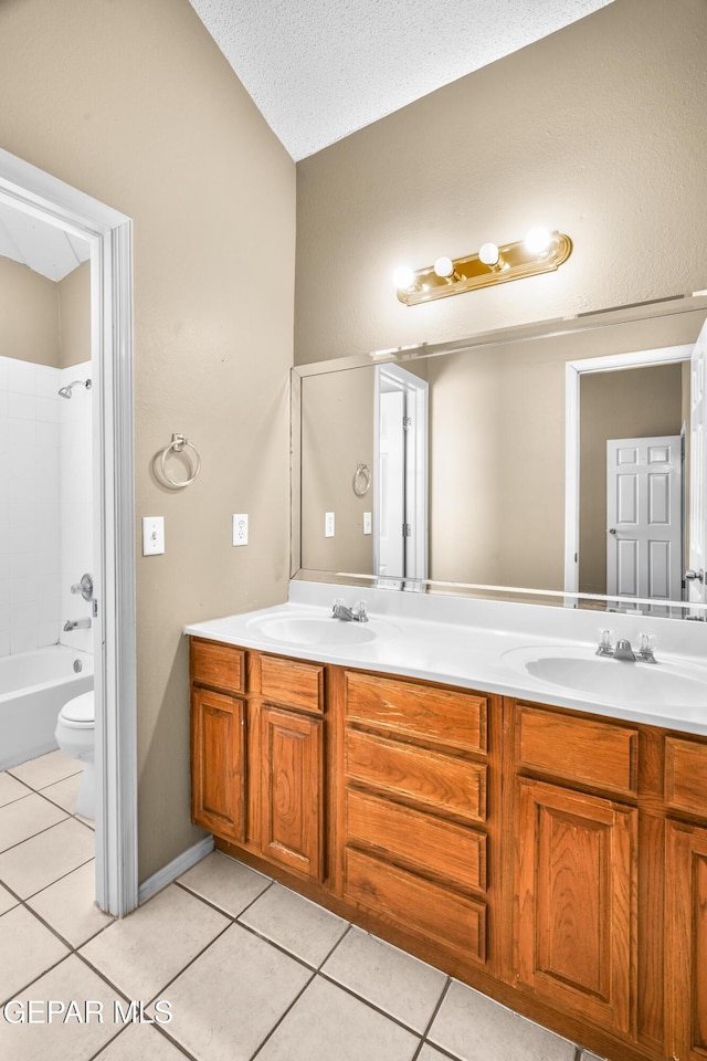 2987 Tierra Limon Dr, El Paso, TX 79938 - full bathroom featuring tile patterned flooring, double vanity, toilet, a textured ceiling, and shower / washtub combination