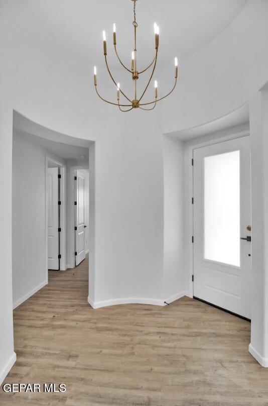 1846 Pommel Pl, El Paso, TX 79911 - interior space featuring a towering ceiling, light wood-style flooring, baseboards, and an inviting chandelier