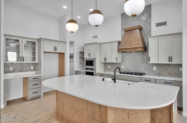 1846 Pommel Pl, El Paso, TX 79911 - kitchen featuring custom exhaust hood, tasteful backsplash, a high ceiling, appliances with stainless steel finishes, and visible vents