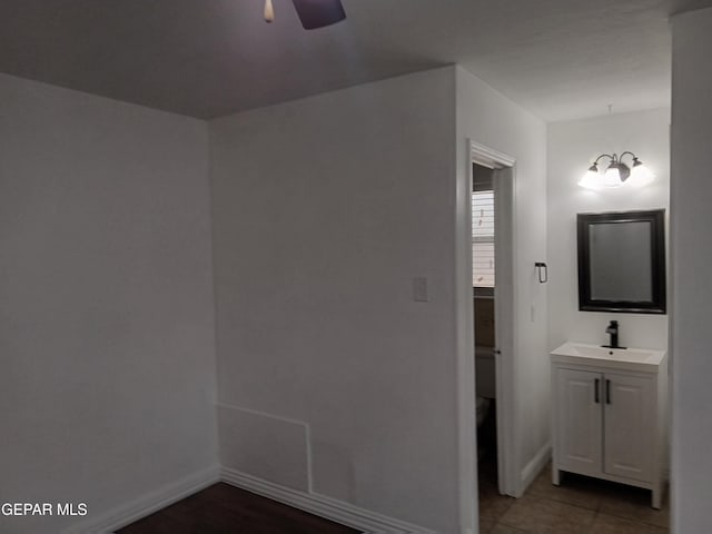 interior space featuring a ceiling fan, vanity, tile patterned floors, and baseboards