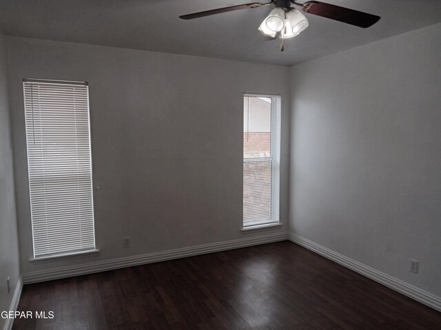 unfurnished room featuring a ceiling fan, dark wood-type flooring, and baseboards