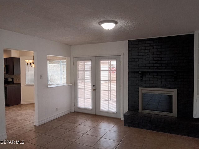 doorway to outside with a fireplace, french doors, and light tile patterned floors