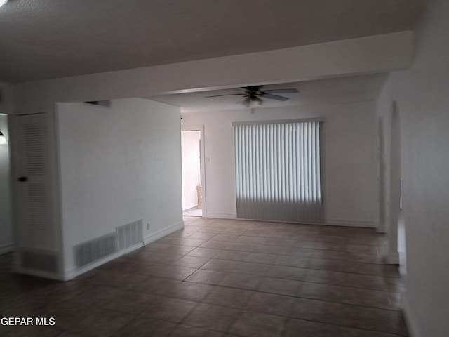 unfurnished room with baseboards, ceiling fan, and visible vents