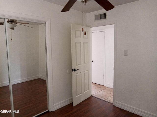 unfurnished bedroom with wood finished floors, baseboards, ceiling fan, and visible vents